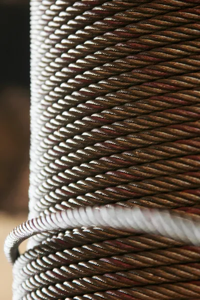 Cable de acero empleado en un área determinada que requiere de mayor resistencia y durabilidad para su función óptima. Cable de acero enrollado sobre una base redonda que facilita su uso para el sector de construcción por la solución de calidad que este brinda.